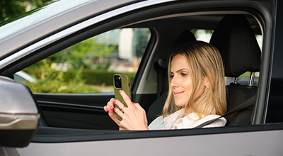 Driver checking Locksure app to verify door is locked while driving
